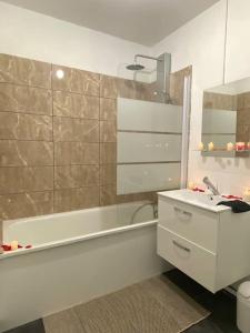 Un baño con lavabo y bañera y un lavabo. en Le Charmant Studio Troyen, en Troyes