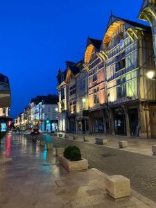 una calle de la ciudad con edificios altos por la noche en Le Charmant Studio Troyen, en Troyes