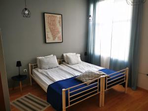 a bedroom with a bed with blue sheets and a window at Radomir Downtown Apartments in Radomir