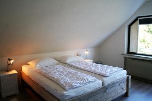 a bedroom with a bed with two pillows and a window at Auf der Platte 2 in Winterberg