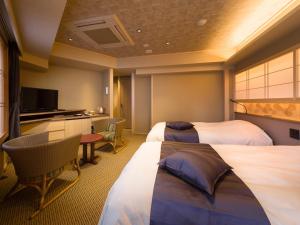 um quarto de hotel com duas camas e uma televisão em Kaneyamaen em Fujiyoshida