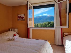 a bedroom with a bed and a window with a view at Le Catalan - Hôtel et appartements in Mont-Louis