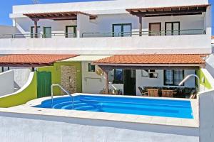 una villa con piscina di fronte a una casa di Casa La Caleta a Los Llanos de Aridane
