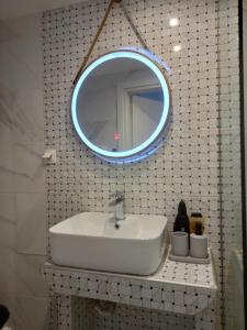 Un baño con un lavabo y un espejo en la pared. en Stylish Downtown Apartment - Tsimiski - Ladadika - Walk Everywhere, en Tesalónica 6 fotos más