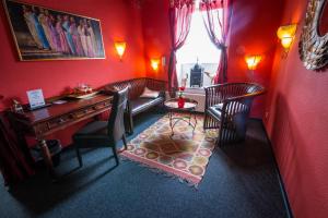 شقق ام مونتزبلاتس الفندقية بخدمة ذاتية في كوبلنز: غرفة حمراء مع مكتب وكراسي وطاولة