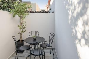 un pequeño patio con mesa negra y sillas en Elvira City Apartment, en La Canea