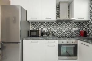 cocina con armarios blancos y papel pintado en blanco y negro en Elvira City Apartment, en La Canea