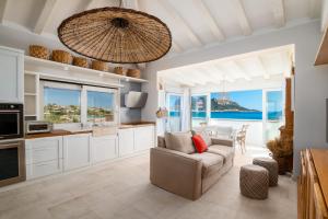 Una cocina y una sala de estar con un sofá y una mesa. en S'Abba seafront apartments - Your House in Sardinia, en Golfo Aranci