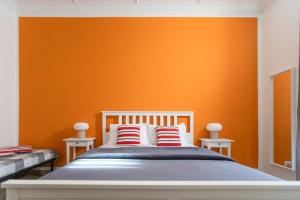 1 dormitorio con 1 cama con pared de color naranja en Zaira b&b en Roma
