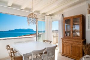 comedor con mesa y vistas al océano en S'Abba seafront apartments, en Golfo Aranci