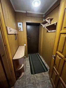 um pequeno quarto com uma porta e um tapete verde em Апартаменты рядом с парком центр em Vinnytsya