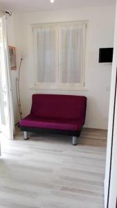 fioletowa ławka w pokoju z oknem w obiekcie Appartamento Valentina: relax e natura w mieście Sirolo