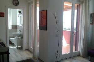 ein Bad mit einer Tür, die sich zu einem Badezimmer mit einem Waschbecken öffnet in der Unterkunft Appartamento Valentina: relax e natura in Sirolo