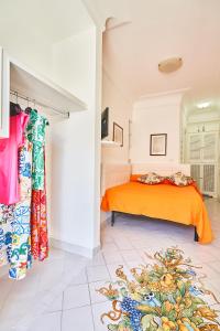 a bedroom with a bed with an orange bedspread at B&B Casa Silvana in Capri