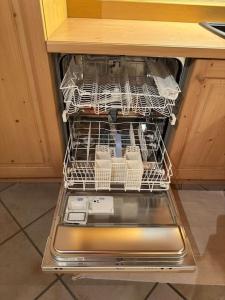 a dishwasher with dishes in it in a kitchen at Tabia studio - Colle Santa Lucia in Villagrande