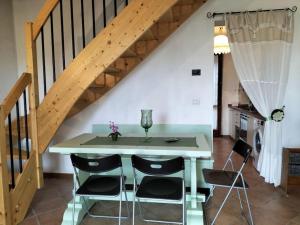kuchnia ze stołem i krzesłami pod schodami w obiekcie Apuan Sunset Apartment w mieście Careggine