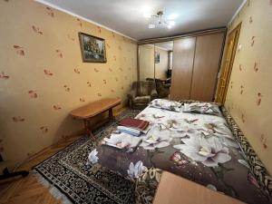 um quarto com uma cama com flores em Апартаменты рядом с парком центр em Vinnytsya
