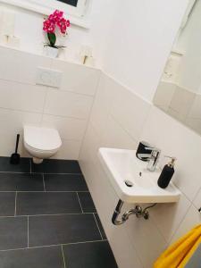 a white bathroom with a sink and a toilet at Leon 3 wunderschönes neues Apartment in Linz