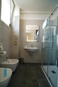 bagno con vasca, lavandino e doccia di Hotel Imperial Beach - Dada Hotels a Rimini
