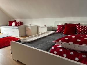 1 dormitorio con 1 cama grande con almohadas rojas y blancas en PöttyösOtthon Vendégház, en Tiszabábolna