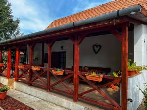 drewniany pawilon z doniczkami na patio w obiekcie PöttyösOtthon Vendégház w mieście Tiszabábolna