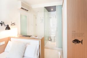 Zimmer mit einem Bett und einer Glasdusche in der Unterkunft Hotel Denit Barcelona in Barcelona