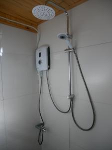 a shower with a shower head in a bathroom at Xô Xôn Homestay in Kon Rơbang