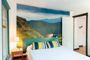 a bedroom with a mountain mural on the wall at Chambres Aguerria Hendaye in Hendaye