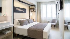 a hotel room with a bed and a bathroom at Hotel Denit Barcelona in Barcelona