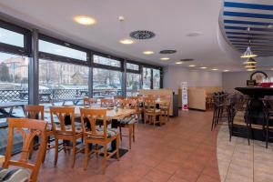 un ristorante con tavoli e sedie in legno e finestre di Hotel Arena a Liberec