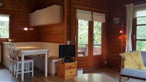 a living room with a table and a tv in a room at Blokhuis Heringhausen-Diemelsee in Diemelsee
