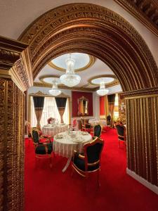 a dining room with a table and chairs on a red carpet at President Luxury in Ploieşti