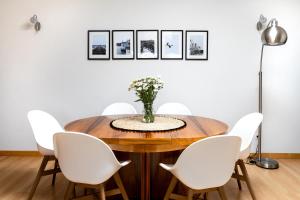 una sala da pranzo con un tavolo di legno e sedie bianche di Sovipral Homes Casa Marina a Olhão