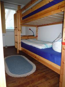 um quarto com 2 beliches e um tapete azul em Meeresrauschen - a72292 em Neuhaus