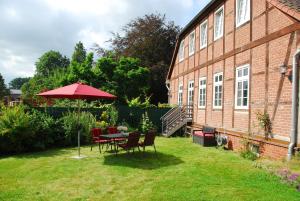 a patio with a table and chairs and an umbrella at Ferienwohnung-Joisten in Kirchgellersen