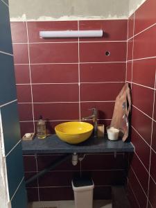 Yeux D'azur في Le Souffleur: حمام مع حوض صفراء على منضدة