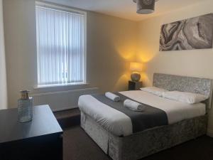 - une chambre avec un grand lit et une fenêtre dans l'établissement Alexander Apartments North Shields, à South Shields