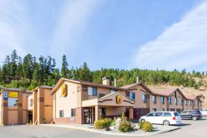 坎卢普斯Super 8 by Wyndham Kamloops On The Hill的停车场停着汽车的酒店