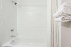 een witte badkamer met een douche en een bad bij Super 8 by Wyndham Kamloops On The Hill in Kamloops
