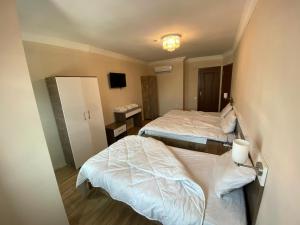 a hotel room with two beds and a mirror at DUVAHi OTEL KONAKLAMA in Adana