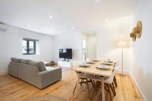 ein weißes Wohnzimmer mit einem Tisch und einem Sofa in der Unterkunft Warm and Cozy Parquet Flooring Apartment in Almada in Almada