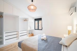 ein weißes Schlafzimmer mit einem Bett und einem Fenster in der Unterkunft Warm and Cozy Parquet Flooring Apartment in Almada in Almada
