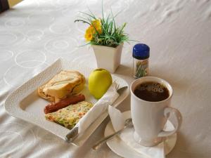einen Teller mit Essen und eine Tasse Kaffee auf dem Tisch in der Unterkunft Yakam Hotel Limited in Kintampo