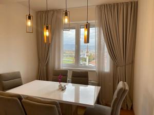 a dining room table with chairs and a large window at شقة نهر اليجا in Sarajevo