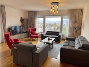 uma sala de estar com um sofá e cadeiras e uma televisão em شقة نهر اليجا em Saraievo