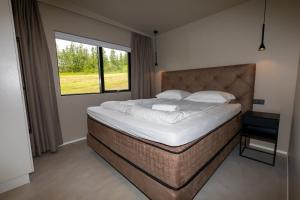 a bedroom with a large bed and a window at North Mountain View Suites in Akureyri