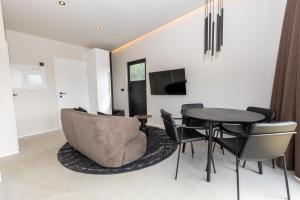 een woonkamer met een tafel en stoelen en een televisie bij North Mountain View Suites in Akureyri