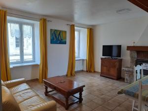 a living room with a couch and a tv at IDAVRO in Saint-Nicolas-du-Pélem
