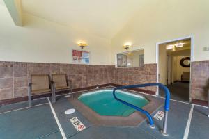 Best Western Plus Northwoods Inn في كريسنت سيتي: مسبح مع حوض استحمام ساخن في مبنى