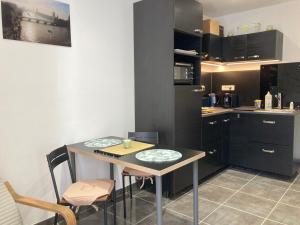 a kitchen with a table and chairs in a room at Centre Vaison-la-Romaine, Appartement T2 in Vaison-la-Romaine